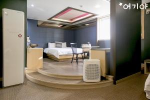 een kamer met een slaapkamer met een bed en een tafel bij Yangsan Seoksan W Hotel in Yangsan