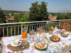 a table with a breakfast of food on a balcony at Villa House and Garden B&B in Montichiari
