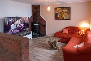 a living room with a red couch and a brick fireplace at Witte Kliff Helgoland in Helgoland
