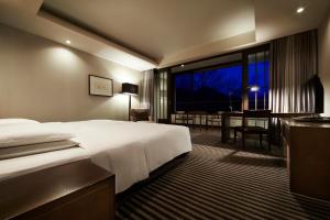 a hotel room with a bed and a desk and a window at Hyatt Regency Hakone Resort and Spa in Hakone +100 photos