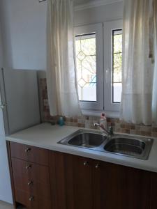 a kitchen with a sink and a window at Endless Blue Apartments in Keratokampos
