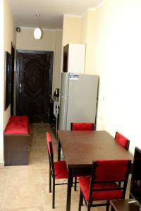 a kitchen with a table and red chairs and a refrigerator at Studio H in Florenza Khamsin in Hurghada