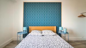 een slaapkamer met een bed met twee blauwe bijzettafels bij Plage à 200 mètres. Vue mer et Esterel ! Rénové in Saint-Raphaël