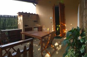 a kitchen with a wooden table and a table and benches at Agriturismo Orione in Marina di Campo