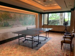 eine Tischtennisplatte in einem Raum mit einem Gemälde in der Unterkunft ホテル グリーンヒル 大多喜 in Ōtaki