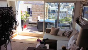 a living room with a couch and a large window at Duplex Terrasse Garage in Granville