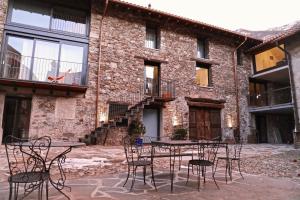 eine Terrasse mit einem Tisch und Stühlen vor einem Backsteingebäude in der Unterkunft Antica Sosta dei Viandanti in Cadenazzo