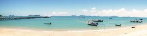 a group of boats sitting in the water on a beach at Baan i Talay Chumphon บ้านไอทะเลชุมพร in Chumphon