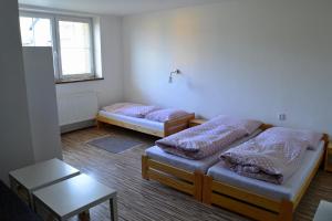 Zimmer mit 2 Betten, einem Tisch und einem Fenster in der Unterkunft Ubytovaní Ve Dvoře II. in Mosty u Jablunkova