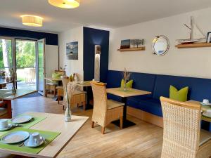 ein Esszimmer mit blauen Wänden sowie einem Tisch und Stühlen in der Unterkunft Hotel Garni Dünennest in Sankt Peter-Ording