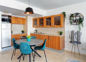 een keuken en eetkamer met een tafel en stoelen bij Beach front lux apartment (pool/gym/parking) in Jlil