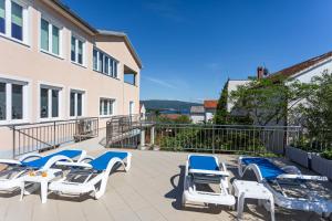 a row of chairs and lounge chairs on a patio at B&B Villa Ana in Krk +24 photos