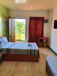 1 dormitorio con 2 camas y ventana en Aosmec Square Hotel en Isla de Mactán