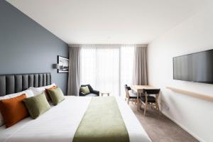 um quarto de hotel com uma cama e uma televisão em Abode Kingston em Camberra