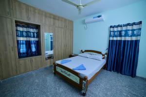 a bedroom with a bed and a window with curtains at TrueLife Homestays - Royal Nagar -Near Railway Station on way to Balaji Temple - Best Location - Mountain View - Fully Furnished 2BHK AC Apartments for Family Stay - Modular Kitchen, Fast WiFi, Android TV - 250 Jio Channels - Top Service with lots of Love in Tirupati