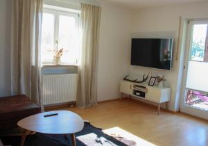 ein Wohnzimmer mit einem TV und einem Tisch in der Unterkunft Ferienwohnung Schott in Rettenberg