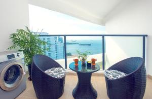 海口市にあるHaikou Bay Hengda Yige Holiday Condo Hotelのテーブルと椅子、洗濯機が備わる客室です。