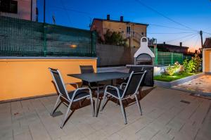 a table and chairs on a patio with a fireplace at Apartments Euphemia in Rovinj