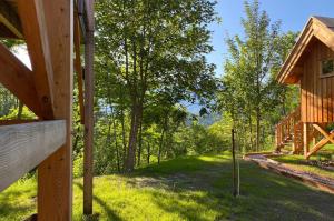 a view from the porch of a log cabin with a swing at Les cabanes du Dauphiné et logis à la ferme in Gap