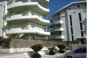 een groot appartementencomplex met een auto voor de deur bij Residence Seaside in Tortoreto Lido