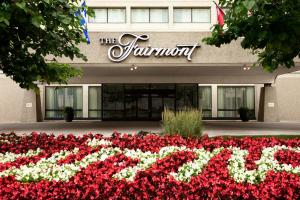 a sign in front of a hotel with red and white flowers at Fairmont Winnipeg in Winnipeg