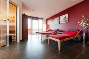 Zimmer mit 3 Stühlen und einer roten Wand in der Unterkunft Riverside Hotel in Nordhorn