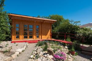 a small wooden cabin with a bridge in a garden at Le Petit Flo in Flocourt