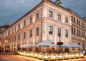 a large building with white umbrellas in front of it at Vanilla Hotel in Lublin