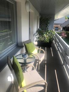 een balkon met 2 stoelen, een tafel en een raam bij Apartma Bled in Bled