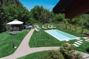 un patio trasero con piscina y tumbonas en Il Bosso del Lago d'Orta en Ameno