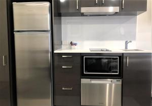 a kitchen with stainless steel appliances and a refrigerator at Quest Kings Park in Perth