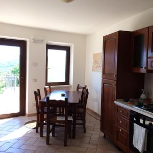eine Küche mit einem Tisch und Stühlen sowie eine Küche mit einem Kühlschrank in der Unterkunft Cominium Benessere in Alvito