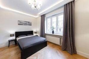 a bedroom with a bed and a large window at Apartamenty-MI Crystal in Warsaw