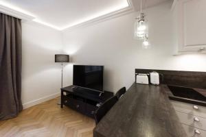 a living room with a table and a flat screen tv at Apartamenty-MI Crystal in Warsaw