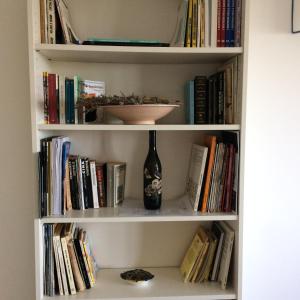 ein Bücherregal mit einer Flasche und einer Vase darauf in der Unterkunft Cominium Benessere in Alvito