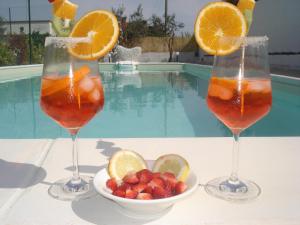 twee glazen sinaasappelsap en een kom aardbeien bij Villa Lara in Polignano a Mare