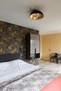 1 dormitorio con 1 cama grande y pared en Abeellogies, en Tielt
