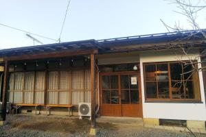 un edificio con panchine poste all’esterno di まるまる貸切一軒家 ゆっくり過ごせる民泊 武甲ステイ a Yokoze