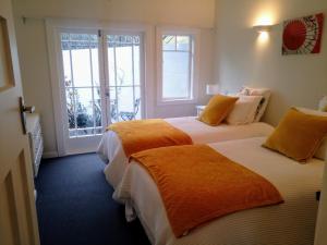 two beds in a room with two windows at Irongate Retreat in Hastings