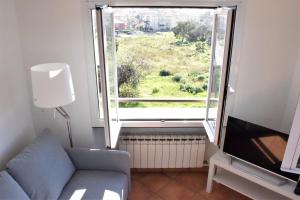 - un salon avec un canapé et une grande fenêtre dans l'établissement Ca Rossa vicino al mare nuova e pulita, à Diano Marina
