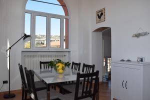 d'une salle à manger avec une table, des chaises et une fenêtre. dans l'établissement Ca Rossa vicino al mare nuova e pulita, à Diano Marina