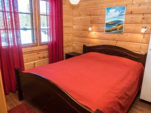 ルカにあるHoliday Home Katajarinne a by Interhomeの木製の部屋に赤いベッドが備わるベッドルーム1室