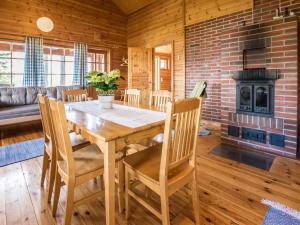 comedor con mesa, sillas y chimenea en Holiday Home Lammassaari by Interhome, en Somerniemi