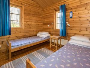 - une chambre avec 2 lits dans une cabane en rondins dans l'établissement Holiday Home Lammassaari by Interhome, à Somerniemi