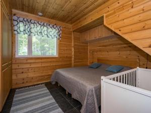 una camera con un letto in una baita di tronchi di Holiday Home Metsäpirtti by Interhome a Saukkokoski