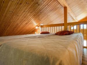 ein großes Bett in einem Zimmer mit Holzdecke in der Unterkunft Holiday Home Metsäpirtti by Interhome in Saukkokoski