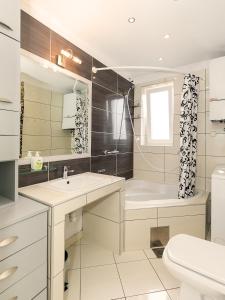 a bathroom with a tub and a sink and a toilet at Apartments Špadići in Poreč +37 photos
