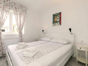 a white bedroom with two white towels on a bed at Apartments Špadići in Poreč