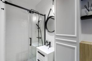 a bathroom with a shower and a sink and a mirror at Andersa 10 by Homeprime in Warsaw