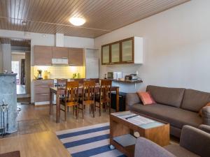 ein Wohnzimmer und eine Küche mit einer Couch und einem Tisch in der Unterkunft Holiday Home Tuija by Interhome in Lahdenperä